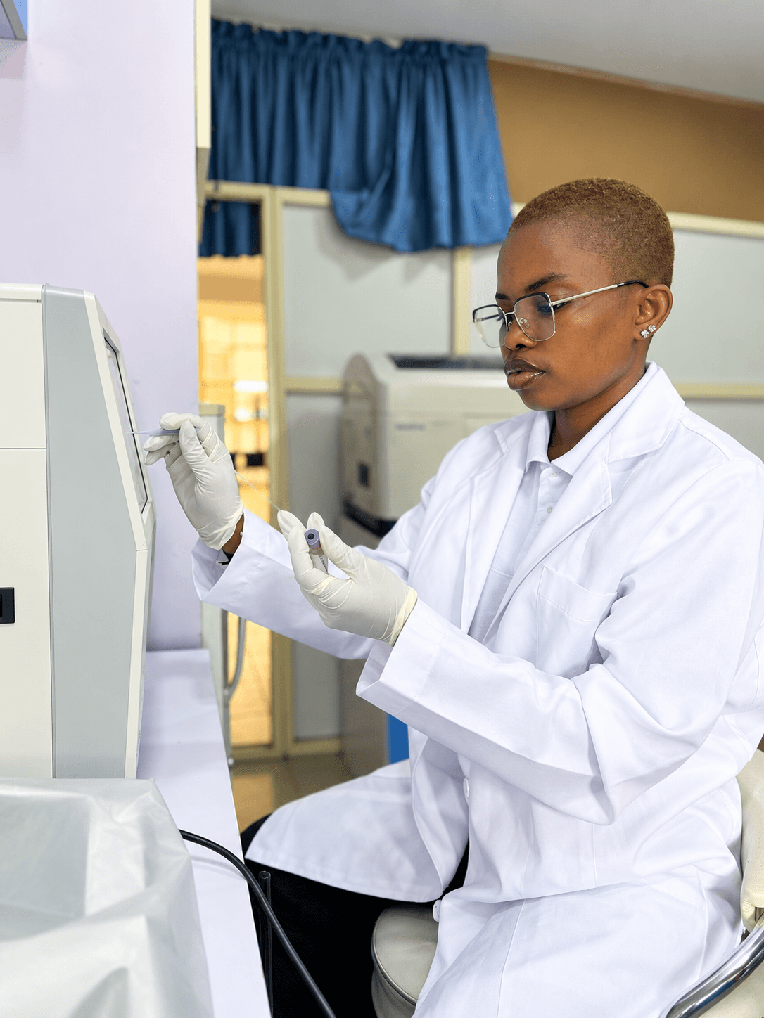 Medical laboratory scientist loading a sample into an analyser